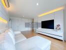 Modern living room with white furniture and a large TV