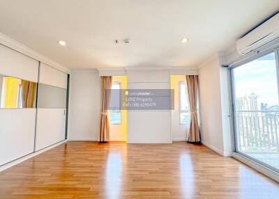 Spacious living room with wooden flooring and large windows