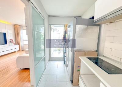 Modern kitchen with white cabinets and large glass doors leading to a balcony