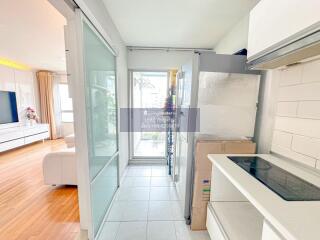 Modern kitchen with white cabinets and large glass doors leading to a balcony