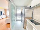 Modern kitchen with white cabinets and large glass doors leading to a balcony