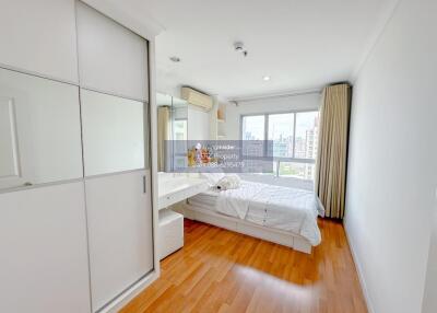 Spacious bedroom with wooden floor, large window, and built-in wardrobe