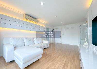 Modern living room with white furniture and wooden flooring