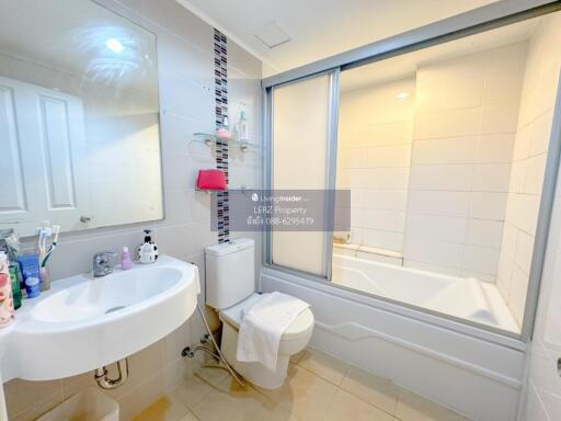 Well-lit modern bathroom with sink, toilet, and bathtub