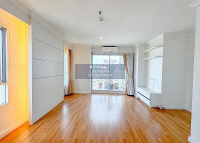 Spacious living room with wooden flooring and large windows