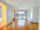 Spacious living room with wooden flooring and large windows