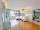 Bright living room with wood flooring, white furniture, and large windows