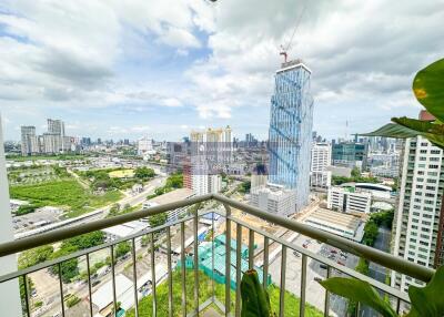 View of the city from the balcony with green spaces and high-rise buildings