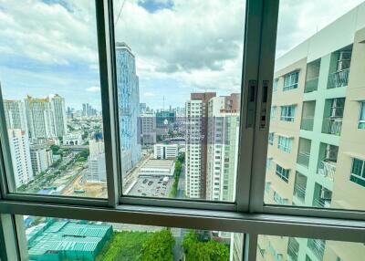 High-rise buildings with a skyline view from a balcony window.