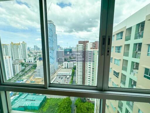 High-rise buildings with a skyline view from a balcony window.