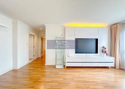 Modern living room with wooden flooring and large TV unit