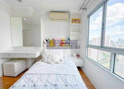 Well-lit bedroom with city view