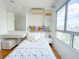 Well-lit bedroom with city view