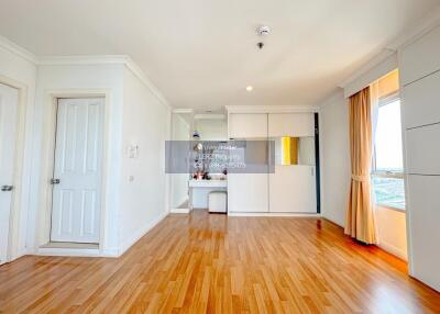 Spacious living room with wooden flooring and large windows