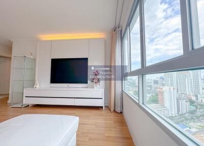 Spacious living room with large windows and city view