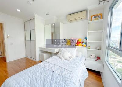 Bright and tidy bedroom with a single bed, built-in wardrobe, and a large window