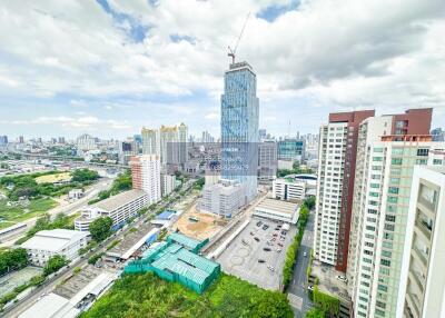 Aerial view of urban area with high-rise buildings, green spaces, and construction site