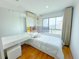 Bright bedroom with large windows and white furnishings