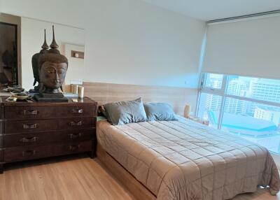 Bedroom with a large window and wooden furniture