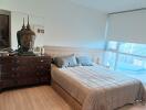 Bedroom with a large window and wooden furniture