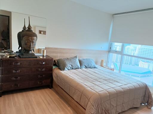 Bedroom with a large window and wooden furniture