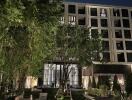 Modern building exterior with garden at night