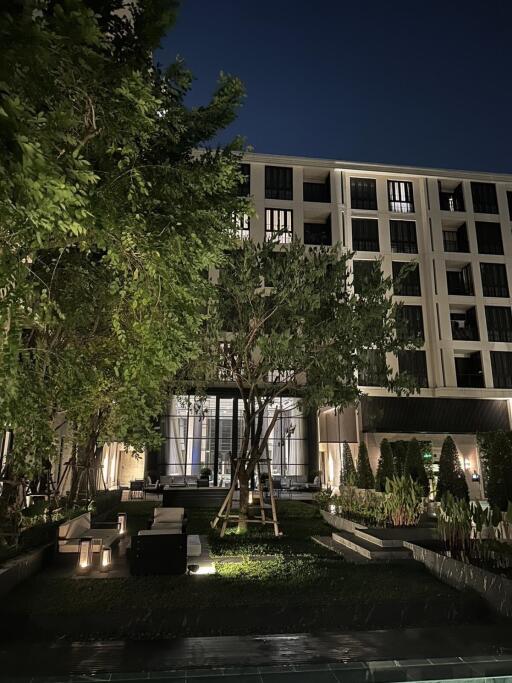 Modern building exterior with garden at night