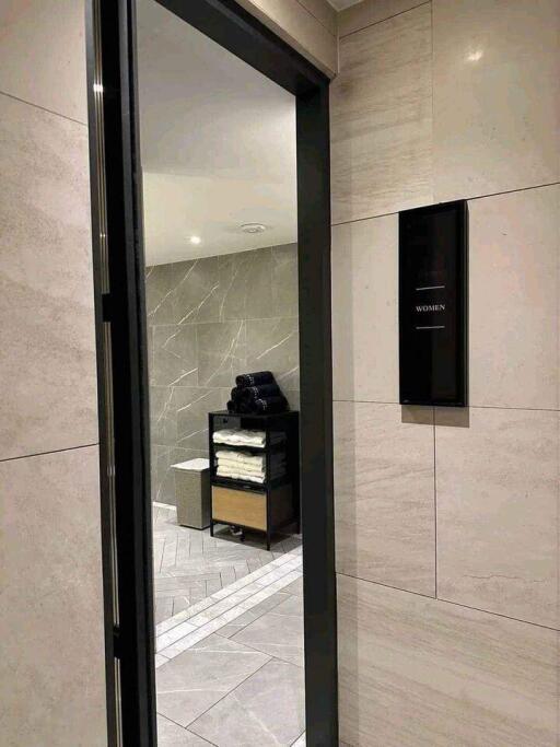 Modern public bathroom entrance with folded towels