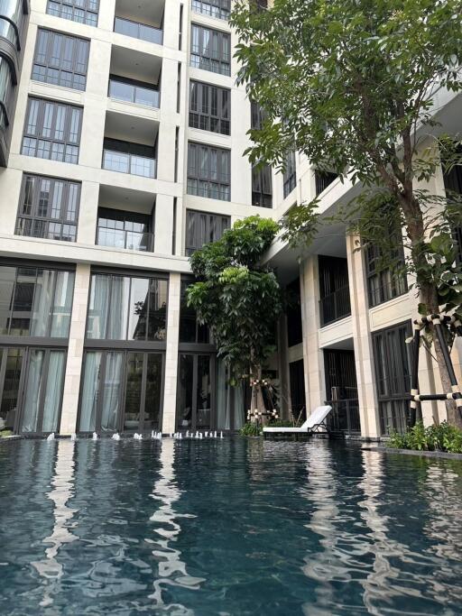 Outdoor pool area in front of a modern residential building