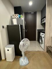 Utility area with a fridge, washing machine, and fan