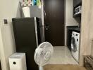 Utility area with a fridge, washing machine, and fan