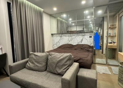 Modern bedroom with a small living area and mirrored closet