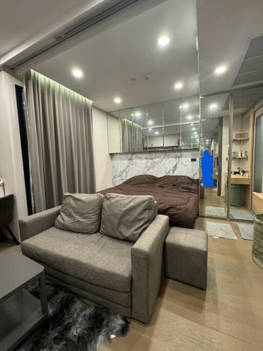 Modern bedroom with a small living area and mirrored closet