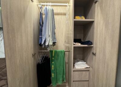 Bedroom closet with hanging clothes and shelves