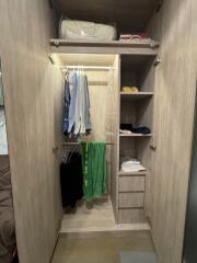 Bedroom closet with hanging clothes and shelves