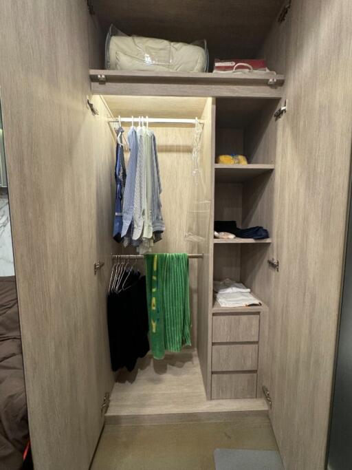 Bedroom closet with hanging clothes and shelves