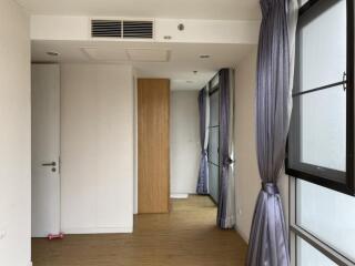 Empty bedroom with wooden flooring and large windows