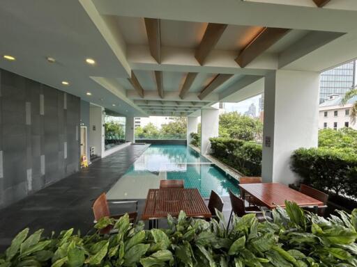 Modern outdoor pool area with seating and greenery