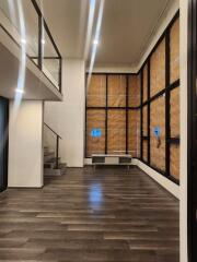 Modern living room with large windows and dark wood flooring