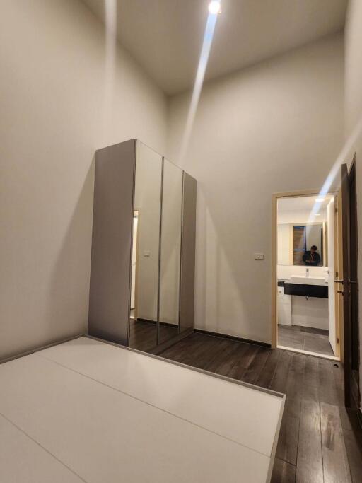 Modern bedroom with mirror wardrobe and view into bathroom