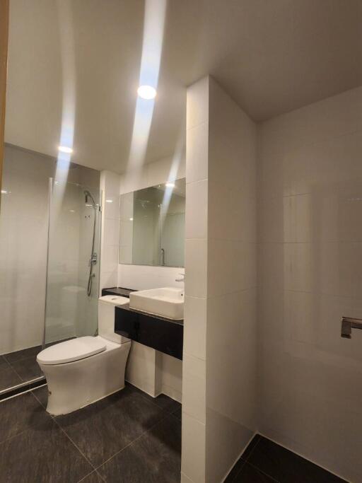 Modern bathroom with shower, toilet, and large mirror