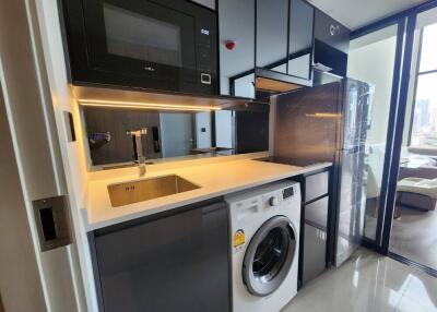 Modern kitchen with built-in appliances including a microwave, washing machine, and refrigerator