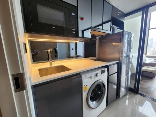 Modern kitchen with built-in appliances including a microwave, washing machine, and refrigerator