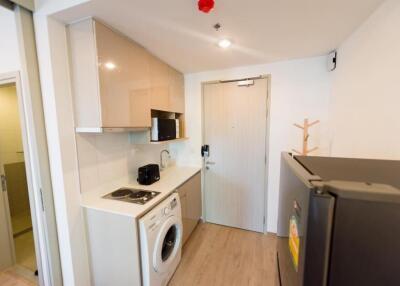 Compact kitchen area with modern appliances and washing machine