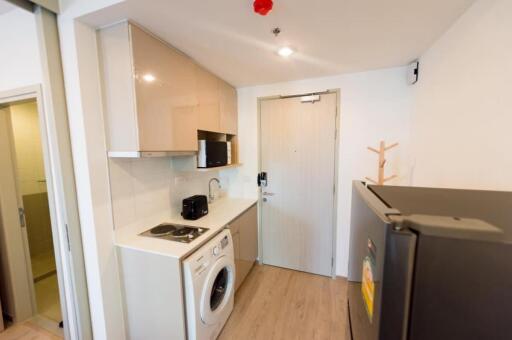 Compact kitchen area with modern appliances and washing machine