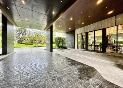 Modern entrance with large glass doors and paved driveway