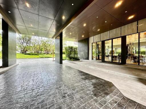 Modern entrance with large glass doors and paved driveway