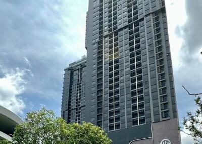 Exterior view of a modern high-rise building with surrounding greenery