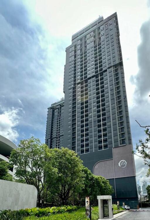 Exterior view of a modern high-rise building with surrounding greenery