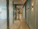 Modern hallway with glass partitions and lit wall sconces